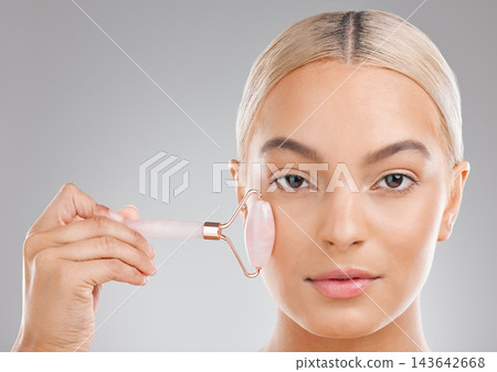 Woman, skincare and quartz roller in studio portrait for facial wellness, health and clean by white background. Girl, person and model with beauty, crystal or gemstone with circulation for skin cells Woman, skincare and quartz roller in studio portrait for facial wellness, health and clean by white background. Girl, person and model with beauty, crystal or gemstone with circulation for skin cells 143642668