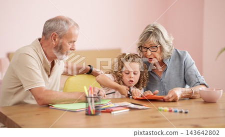 Grandparents and granddaughter bonding while crafting at home Grandparents and granddaughter bonding while crafting at home 143642802
