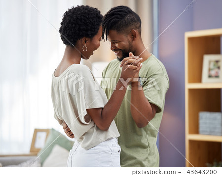 Black couple, dancing and hug in living room happy and in love for relationship, romance or commitment. Smiling, man and woman embrace in home together for relaxing, dating fun and bonding on weekend Black couple, dancing and hug in living room happy and in love for relationship, romance or commitment. Smiling, man and woman embrace in home together for relaxing, dating fun and bonding on weekend 143643200