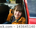 Portrait of smiling boy sitting in red car during family road trip, happy child passenger looking out, autumn travel and vacation concept 143645140