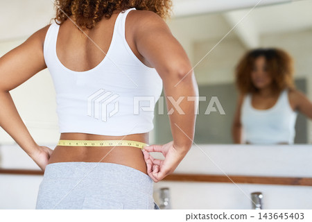 Mirror, woman and tape measure in bathroom for weight loss, progress and results at home. Person, measuring and waist with development for goal, health and diet routine for improved physical health Mirror, woman and tape measure in bathroom for weight loss, progress and results at home. Person, measuring and waist with development for goal, health and diet routine for improved physical health 143645403