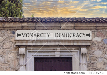 Democracy or monarchy words symbol. Concept words Democracy Monarchy on beautiful white sign plate. Beautiful stone wall background. Business democracy monarchy concept. Copy space 143645730