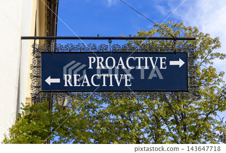 Proactive and reactive symbol. Concept word Proactive Reactive on beautiful black road sign. Beautiful blue sky background. Business proactive and reactive concept. Copy space. Proactive and reactive symbol. Concept word Proactive Reactive on beautiful black road sign. Beautiful blue sky background. Business proactive and reactive concept. Copy space. 143647718