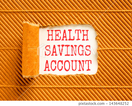 Health saving account symbol. Concept words Health saving account on beautiful white paper. Beautiful brown background. Medical Health saving account concept. Copy space. Health saving account symbol. Concept words Health saving account on beautiful white paper. Beautiful brown background. Medical Health saving account concept. Copy space. 143648252