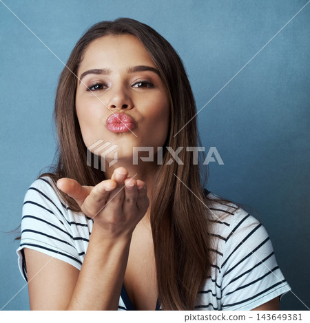 Blow kiss, blue background and portrait of woman for romance, affection and gratitude in studio. Beauty, confidence and face of happy person with flirting emoji, love hand gesture and thank you Blow kiss, blue background and portrait of woman for romance, affection and gratitude in studio. Beauty, confidence and face of happy person with flirting emoji, love hand gesture and thank you 143649381