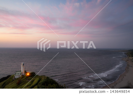從角田岬燈塔眺望日本海,夕陽西下,天空被染成粉紅色,構成了一個美麗的景象。 從角田岬燈塔眺望日本海,夕陽西下,天空被染成粉紅色,構成了一個美麗的景象。 143649854