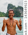 Friendly asian man giving thumbs up on a tropical boat trip 143649923