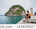 Man pointing at karst island from longtail boat in phang nga bay 143649927