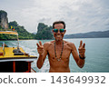 Man smiling and posing on a boat in thailand's tropical sea 143649932