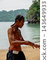Local man engaging in conversation on tropical beach 143649933