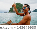 Thai boatman smiling, giving thumbs up, enjoying ocean travel 143649935