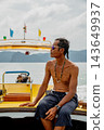 Man wearing sunglasses traveling on longtail boat looking at horizon 143649937