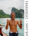 Smiling man giving thumbs up on boat trip 143649941