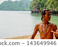 Thai man standing on tropical beach by ocean 143649946
