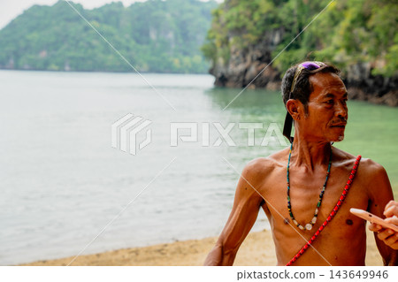 Thai man standing on tropical beach by ocean 143649946