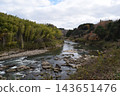 A river flowing through shallow, rocky waters. 143651476