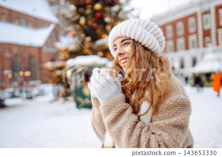 Beautiful woman playing with snow on winter street. Fashion young woman in the winter park. Beautiful woman playing with snow on winter street. Fashion young woman in the winter park. 143653330
