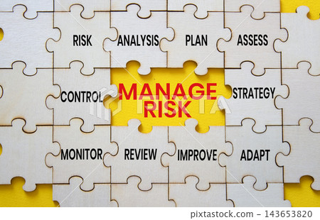 Manage Risk text on wooden puzzle pieces with strategy puzzle piece over yellow background. Business risk management and strategic planning concept with copy space. Manage Risk text on wooden puzzle pieces with strategy puzzle piece over yellow background. Business risk management and strategic planning concept with copy space. 143653820
