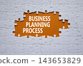Business Planning Process symbol. White puzzle with words Business Planning Process. Beautiful orange background. Business concept. Copy space. 143653829