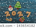 Festive gingerbread cookies for Christmas and New Year 2027 with spices and decorations on a dark wooden table 143654182