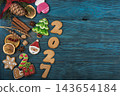 Festive gingerbread cookies for Christmas and New Year 2027 with spices and decorations on a dark wooden table 143654184
