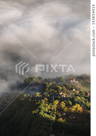Aerial View of Forested Village in Morning Fog Aerial View of Forested Village in Morning Fog 143654414