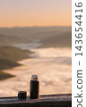 Thermos Flask Overlooking Foggy Mountain Valley 143654416