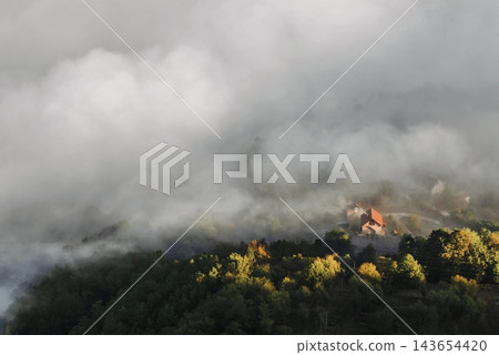 Sunlight Illuminating Foggy Mountain Village Sunlight Illuminating Foggy Mountain Village 143654420
