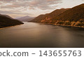 Scenic aerial landscape of Zhinvali reservoir surrounded by green mountain slopes under hazy sky during evening sunset in Georgia 143655763