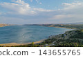 Panoramic drone view of Tbilisi sea reservoir with clear blue water and sandy coastline under cloudy sky on sunny summer day in Georgia 143655765