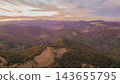 High angle panoramic view of rolling mountain ranges and forested valleys bathed in soft sunset light in the rural countryside of Georgia 143655795