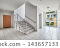 Modern apartment building staircase hall with elevator, wooden door, and panoramic window. 143657133