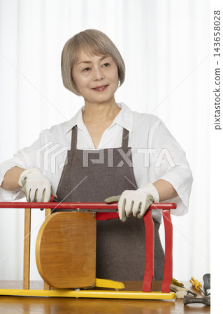 一位老婦人在客廳裡製作椅子，這是她的DIY愛好。 143658028