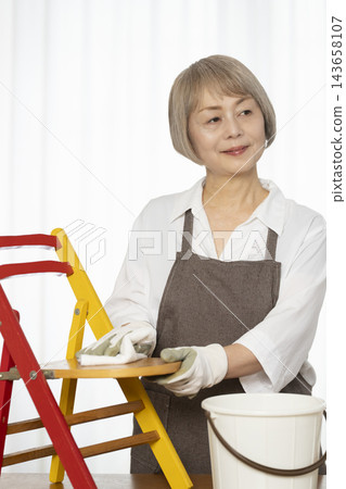 一位老婦人在客廳裡製作椅子,這是她的DIY愛好。 一位老婦人在客廳裡製作椅子,這是她的DIY愛好。 143658107