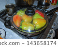 Fresh bell peppers frying in a skillet on a gas stove grill. 143658174