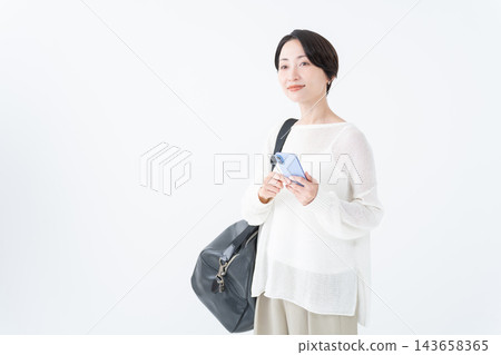 A woman going out with a large bag and her smartphone 143658365
