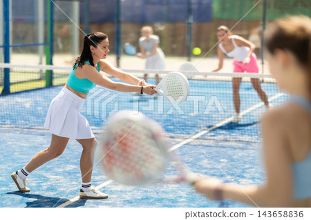 Woman playing with other paddle tennis players Woman playing with other paddle tennis players 143658836