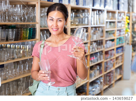 Woman buying glassware in household shop 143659027