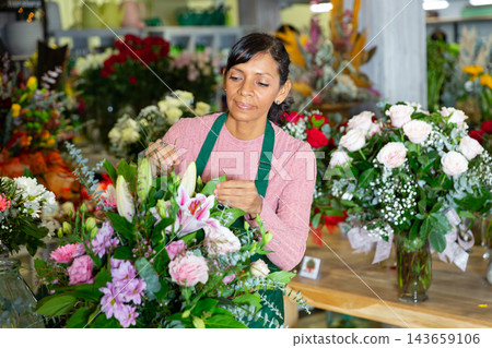 Latin woman florist working in floral shop Latin woman florist working in floral shop 143659106