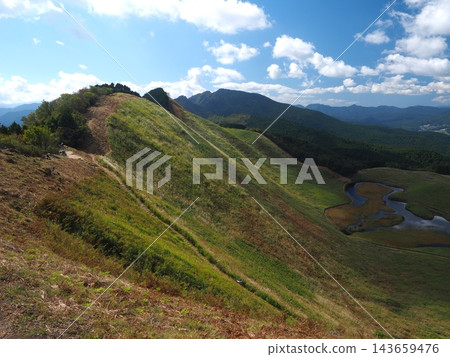 風吹拂過的山脊步道。從索尼高原索尼村龜山峠眺望秋季全景。 風吹拂過的山脊步道。從索尼高原索尼村龜山峠眺望秋季全景。 143659476