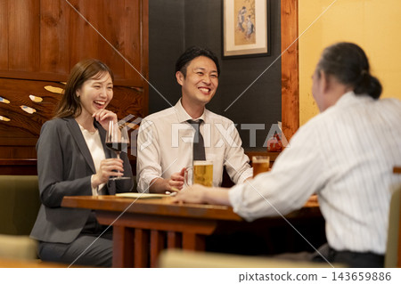 下班後,一對男女在居酒屋(日式酒吧)聊天。 下班後,一對男女在居酒屋(日式酒吧)聊天。 143659886