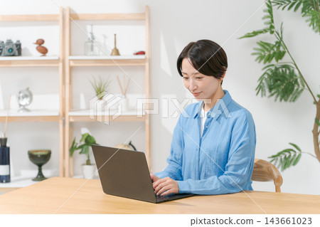 Young woman using a computer in the living room Young woman using a computer in the living room 143661023