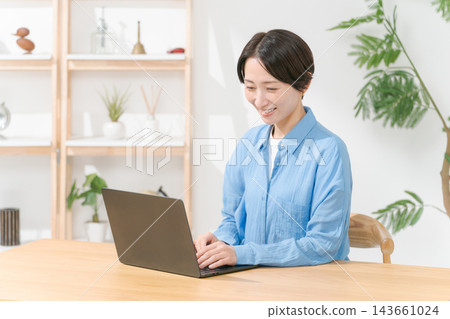 Young woman using a computer in the living room Young woman using a computer in the living room 143661024