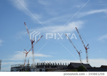 A large crane above a construction site A large crane above a construction site 143661208