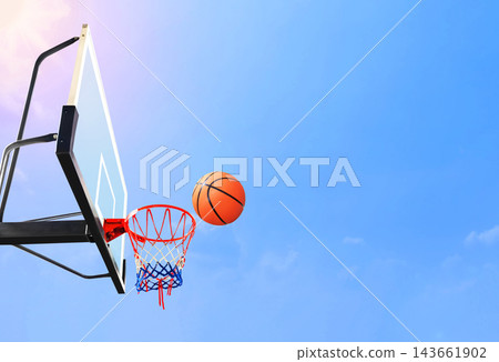 Basketball flying into the hoop against clear blue sky. Basketball flying into the hoop against clear blue sky. 143661902