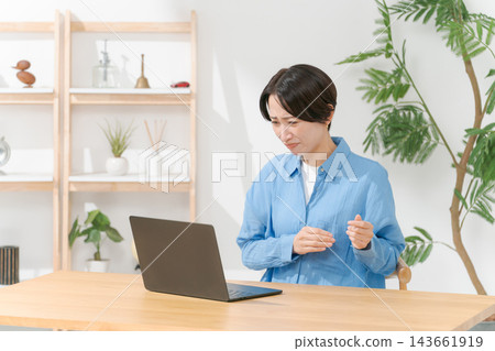 使用一台電腦在客廳裡的年輕女子 143661919