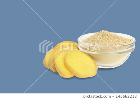 Ginger slices and powder are displayed elegantly on blue backdrop Ginger slices and powder are displayed elegantly on blue backdrop 143662218