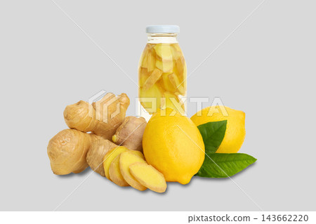 Ginger and lemons are arranged with infused ginger water in bottle 143662220