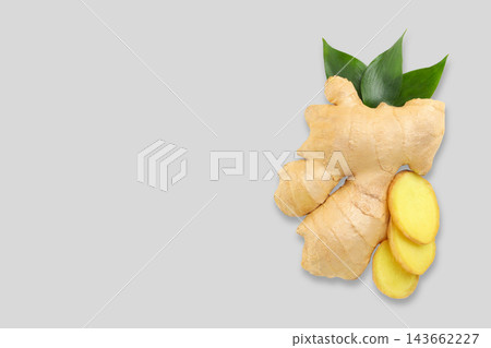 Fresh ginger root and slices arranged beautifully with green leaves Fresh ginger root and slices arranged beautifully with green leaves 143662227