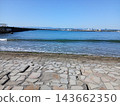 湛藍的天空和輕柔的波浪勾勒出迷人的海濱景色。 143662350